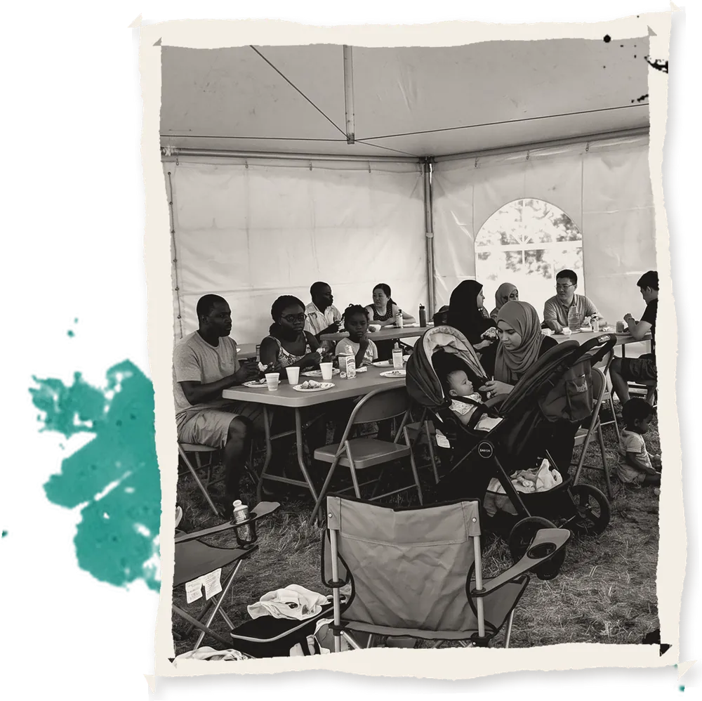 Families resting under a shade tent