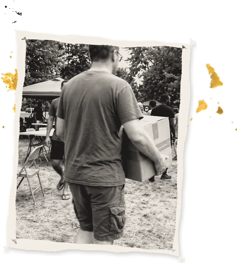 A volunteer carrying a box across the field